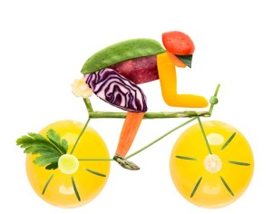 Fruits and vegetables in the shape of a male cyclist on a road bike.